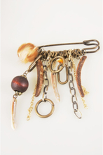 Bronzen kiltspeld met kettinkjes, bedels, kralen en pompoentje